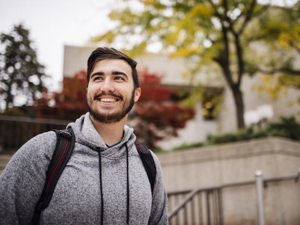 Student smiling while standing outside the library