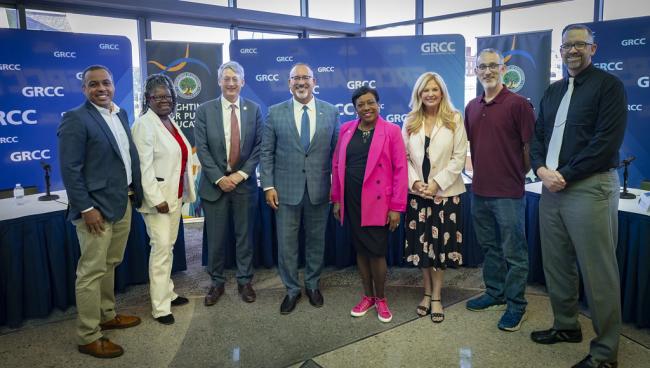 U.S. Secretary of Education Miguel Cardona poses for a photo with other participants of a roundtable talk.