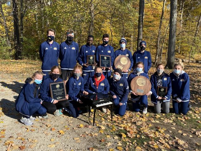 Team photo of cross country teams holding their championship plaques