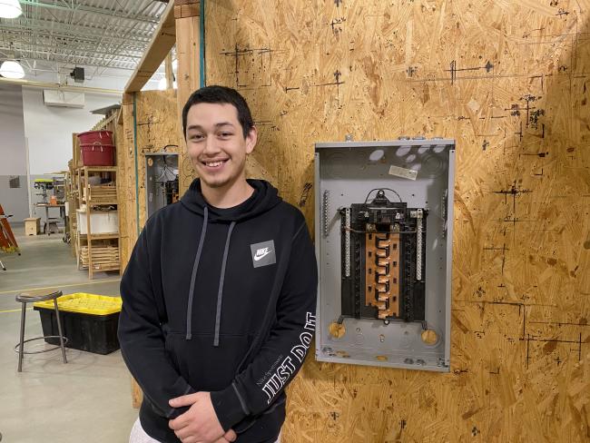Photo of Alec Alvarado posing in the construction electrical lab.