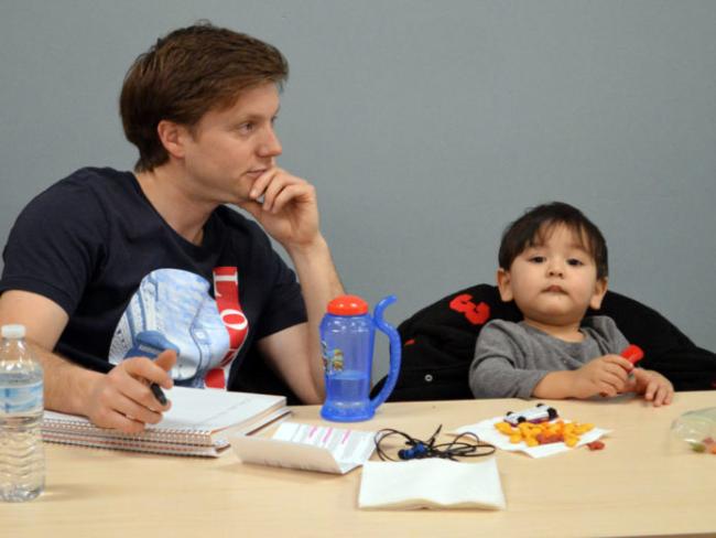 GRCC student Chad Hamilton sitting at a table attends a workshop on depression with his son, Caelan, 2, for a class he is taking