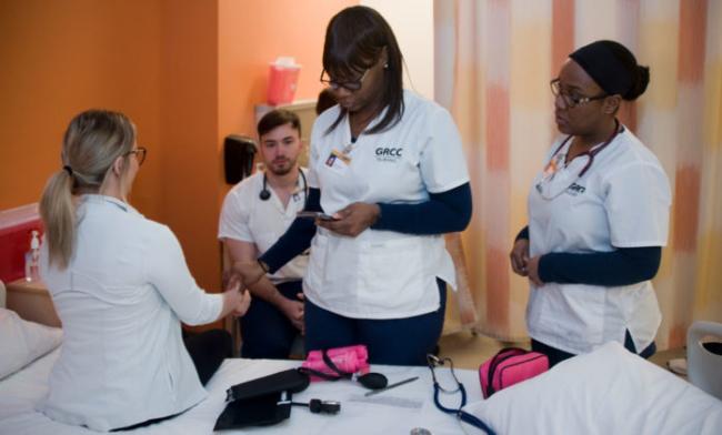 Payle Delalic gets her pulse taken by LPN student Turkesha Hankins while students Mustafa Ajanovic and Deanna Darrell look on.
