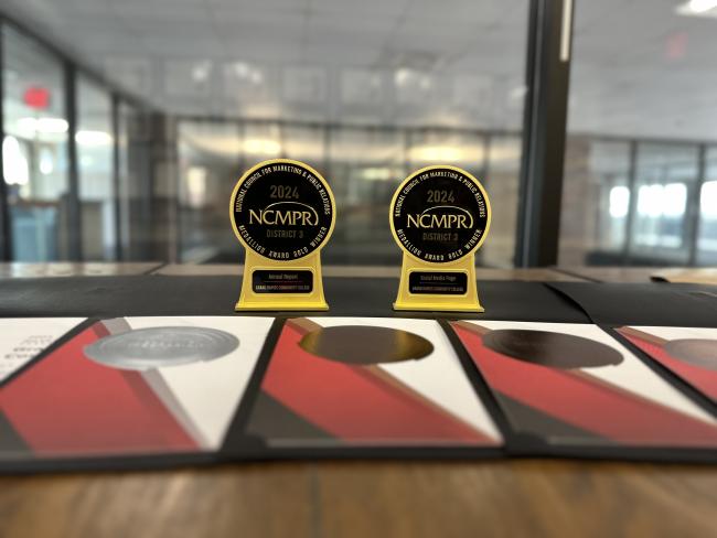 Seven awards placed on a table, representing the recognition GRCC's Marketing and Communications team received from the National Council for Marketing and Public Relations.