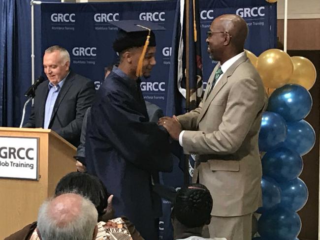 President Bill Pink shakes the hand of a Job Training graduate.