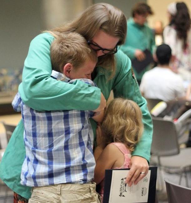 Metallica Scholar Krista Steffens hugs her two children after earning her certificate