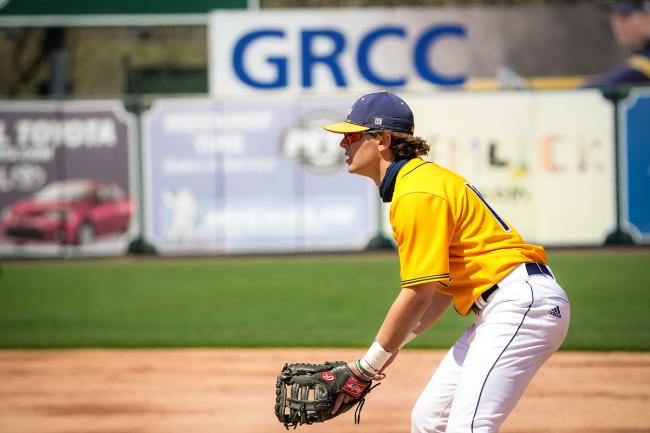 GRCC baseball player on the field with the GRCC ad behind him. 