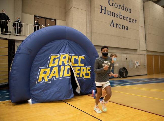 GRCC basketball players running through an inflatable tunnel.