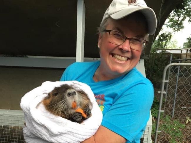 Carolyn Miller holding an animal that might be a ground hog.