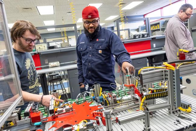Two students work with equipment in the Mechatronics lab.