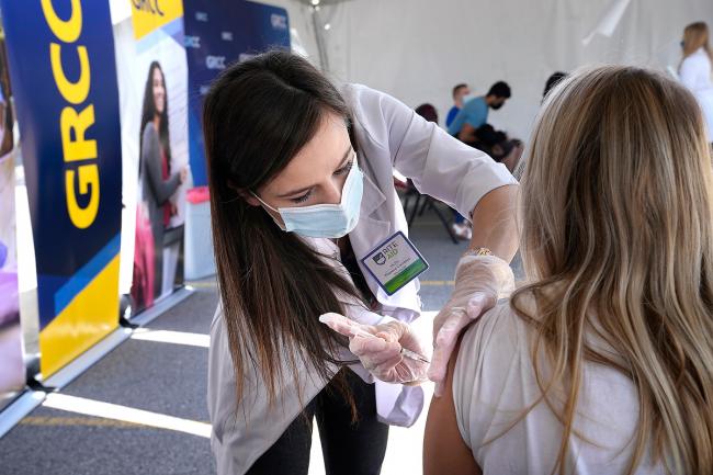 A GRCC students receives a vaccination shot at the May outdoor clinic.