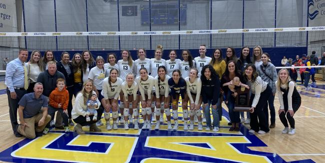 Current GRCC volleyball players surrounded by alumni.