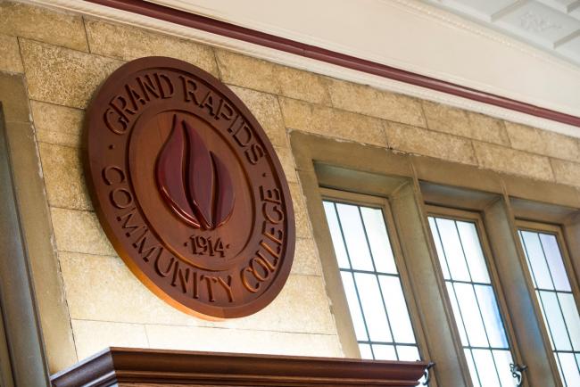 A wooden sign with the GRCC seal hanging in the board of trustees meeting room.