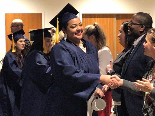 A Medical Assistant graduate shakes Amy Mansfield's hand.