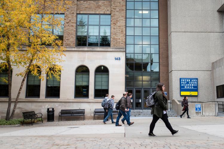 Students walking in front of the Peter and Pat Cook Academic Hall.