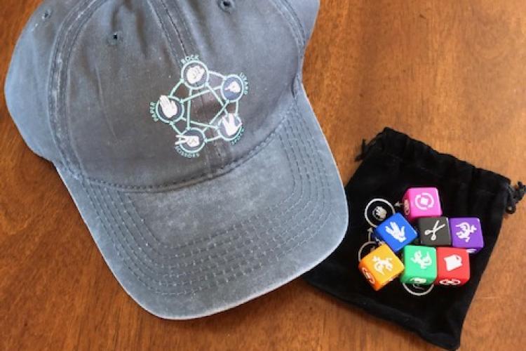 A hat and a set of seven die with a "Rock, Paper, Scissors, Lizard, Spock" theme.