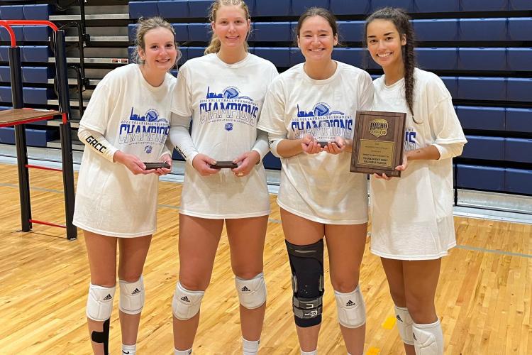 GRCC volleyball players named to the All-Tournament Team holding their trophies.