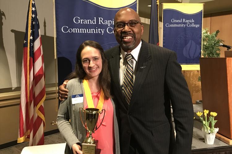 Heather Stadt holds the Arthur Andrews Award. President Pink stands next to her with his arm on her shoulder.