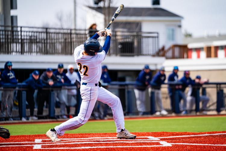 Caleb Englesman at the plate, following through on a swing.