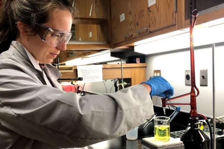 A chemist in the GR Water Department looking at a sample. 