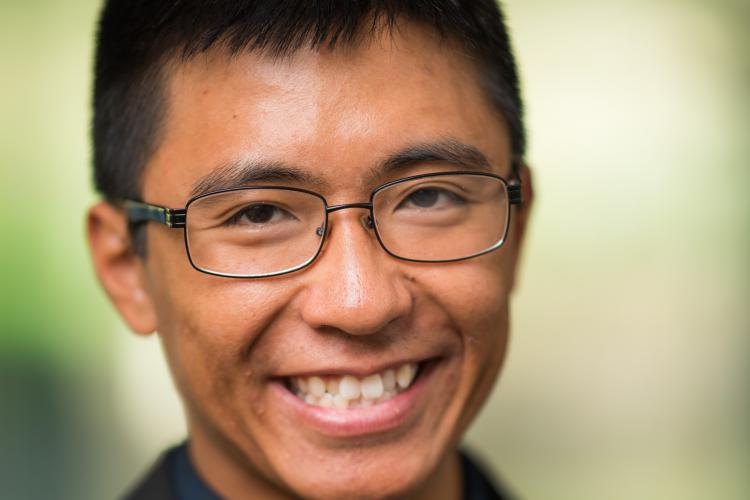 Headshot of Don Hua, wearing a suit and tie.