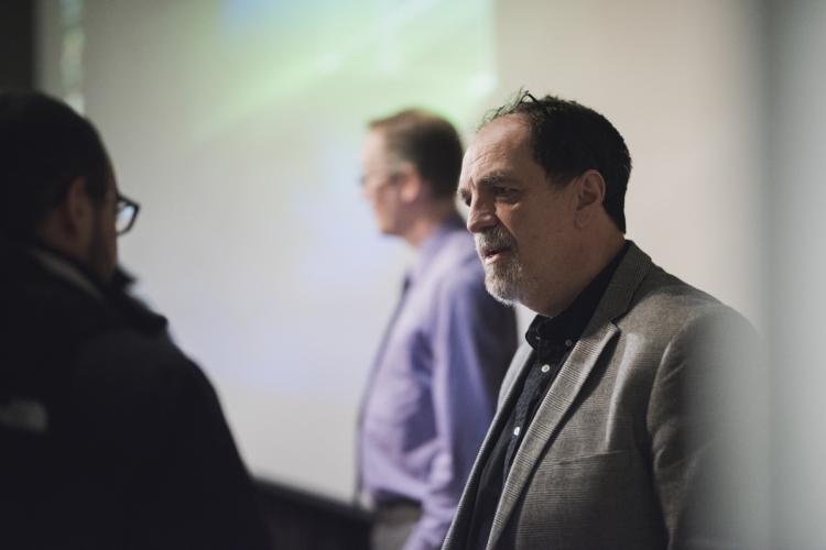 Professor Frank Conner, who organizes the Psychology Speakers Series, speaking to a person at the event