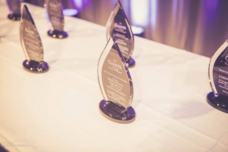 Giant Awards trophies sitting on a table. They are clear, teardrop-shaped awards.