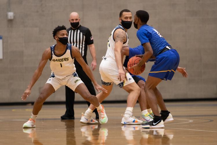 GRCC basketball players playing defense in a game.