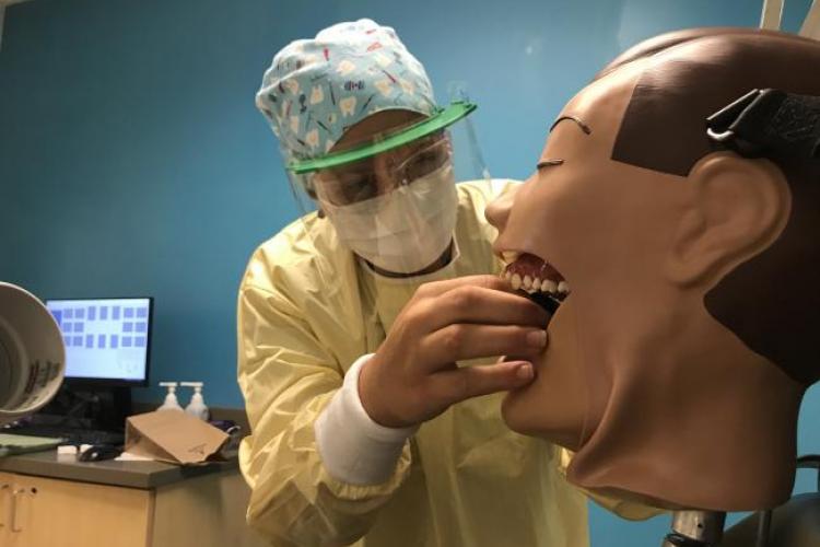 Dental student Sydney Heyboer learning how to take x-rays, wearing her PPE.