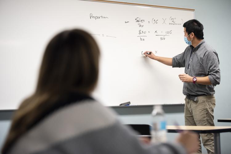 A math professor at the board in an on-campus class.