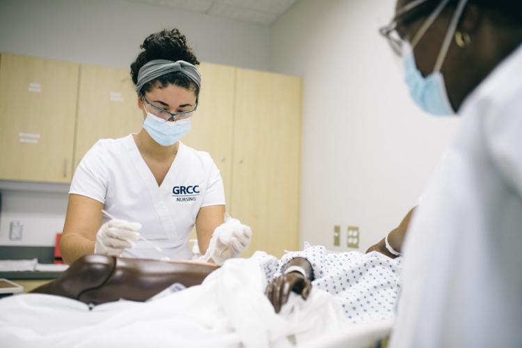 GRCC Nursing students working with a mannequin. 