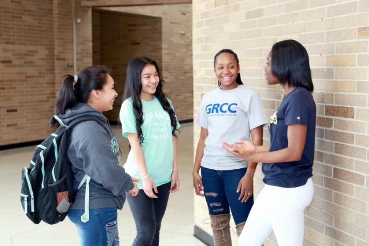 Students in the GRCC middle college program speaking with staff members at Ottawa Hills High School