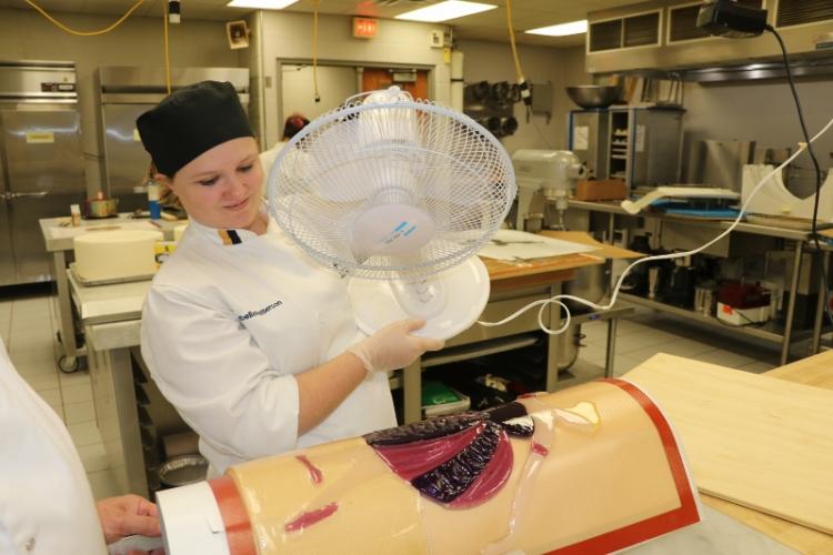 A student uses a portable fan to cool a sugar ballerina.