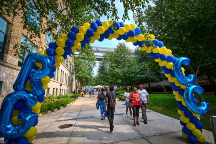 Students walking under a balloon arch at Raider Rally