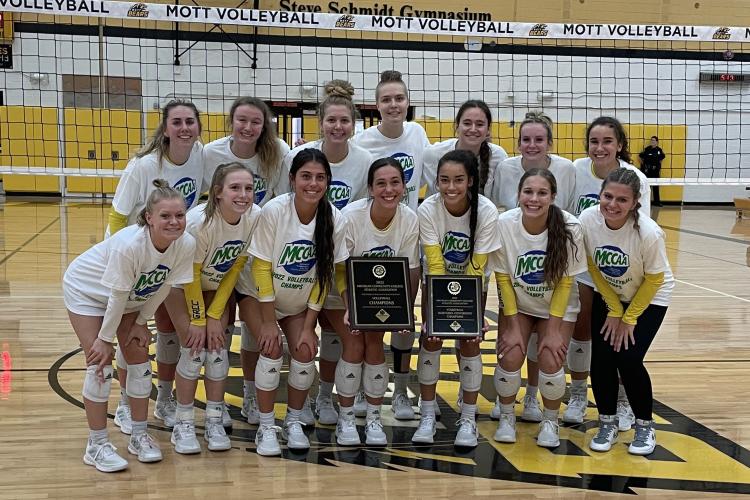 GRCC volleyball team players posing with their new trophies.