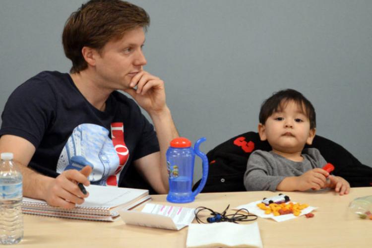 GRCC student Chad Hamilton sitting at a table attends a workshop on depression with his son, Caelan, 2, for a class he is taking