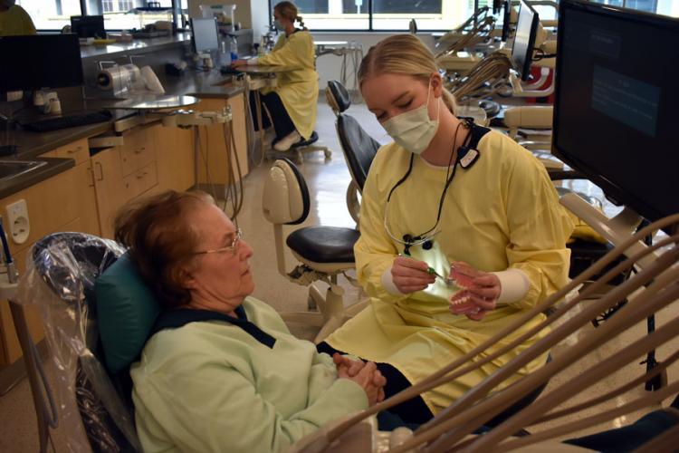 Second-year dental hygiene student Chyna Schut shows her patient, Mary Tucker, how to properly brush her teeth and gums at GRCC’s Senior Dental Day.