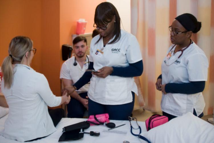 Payle Delalic gets her pulse taken by LPN student Turkesha Hankins while students Mustafa Ajanovic and Deanna Darrell look on.