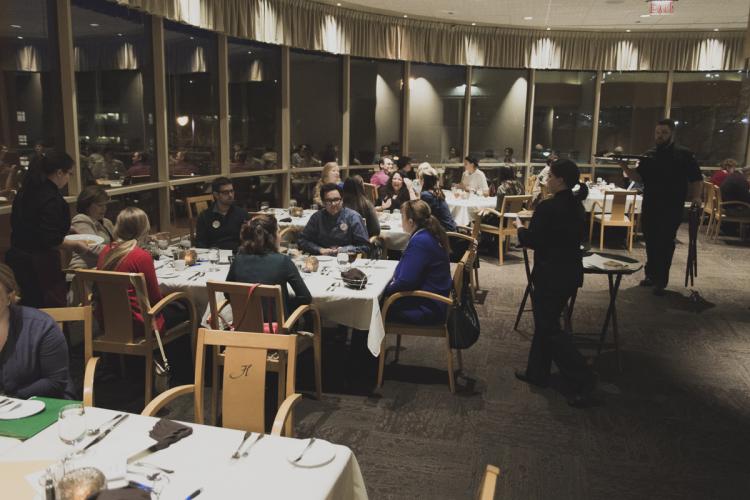 Heritage wait staff serve meals to Honors students participating in a mystery dinner.