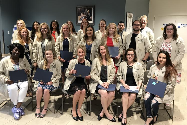 The 21 Medical Assistant students hold their certificates.