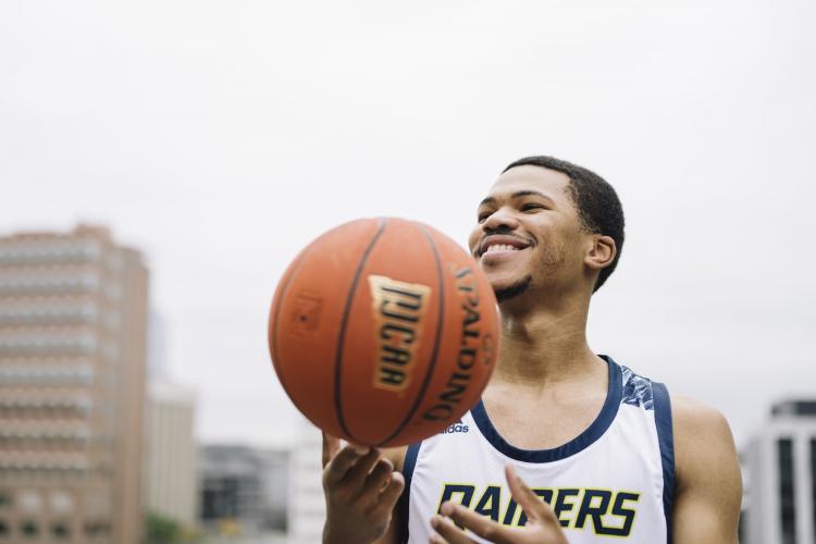 Portrait of Justus Clark with a basketball.