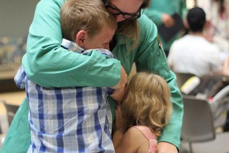 Metallica Scholar Krista Steffens hugs her two children after earning her certificate