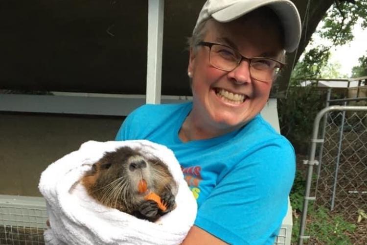 Carolyn Miller holding an animal that might be a ground hog.