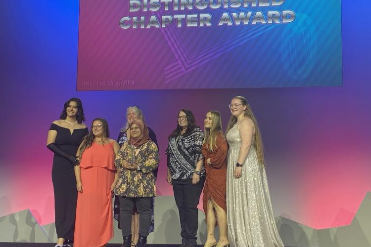 GRCC chapter members presented with one of their awards on stage.