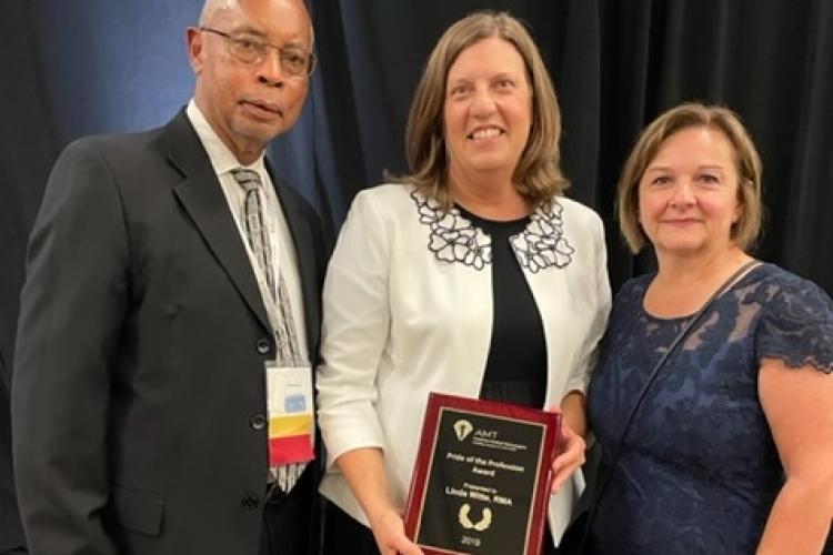 Linda Witte receiving her award. On her right is the President of the Board of Directors, Christopher Seay, and to her left is the Executive Director of AMT, Kathy Cilia.