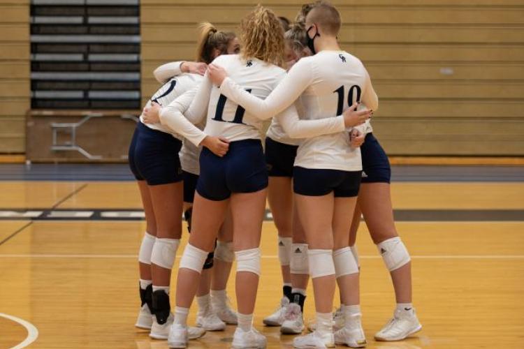 Volleyball players gather in a circle.