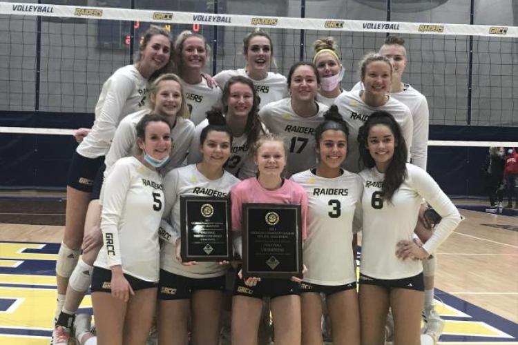 The volleyball team poses with championship awards.