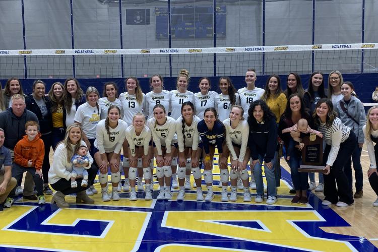 Current GRCC volleyball players surrounded by alumni.