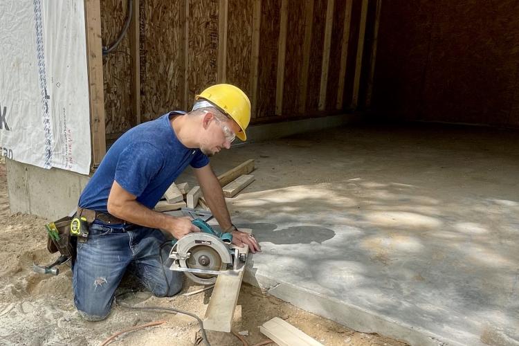 Joshua Middleton working with a saw on a construction project.