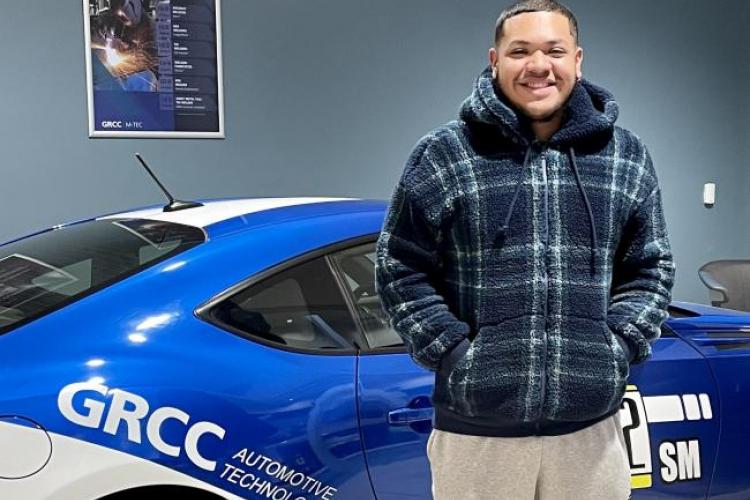 Kevin Rios posing with a car in the M-TEC.