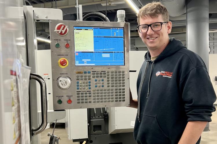 Matthew Collins working a machine in the CNC lab.